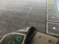 Dywan z motywem DOMINO - zdjęcie, ramowy układ wzoru ułożony z kostek domino, z jednolitym szarym środkiem -